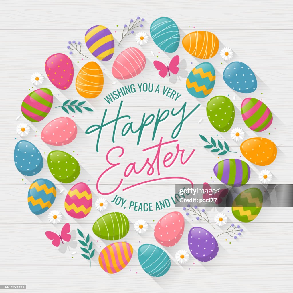 Easter wreath greeting card with colorful eggs and daisies on wood background.