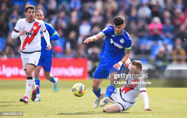 Carles Alena of Getafe CF is tackled by Ivan Balliu of Rayo Vallecano during the LaLiga Santander match between Getafe CF and Rayo Vallecano at...