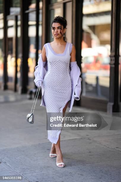 Guest wears crystal pendant earrings, a pale purple and white braided wool / V-neck / sleeveless / fishnet slit long dress, a pale purple jacket,...