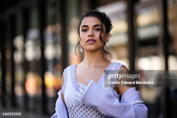 Guest wears crystal pendant earrings, a pale purple and white braided wool / V-neck / sleeveless / fishnet slit long dress, a pale purple jacket,...