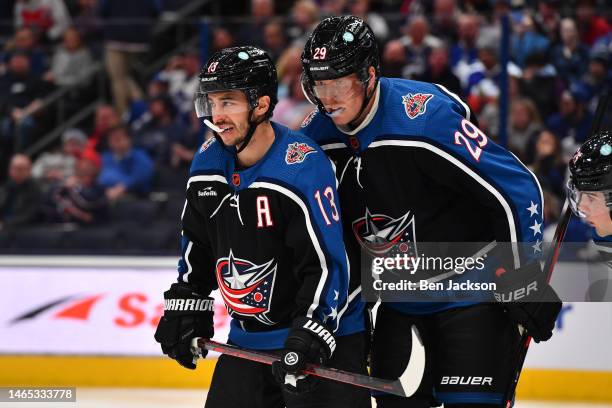 Patrik Laine talks with teammate Johnny Gaudreau of the Columbus Blue Jackets prior to a face-off during the second period of a game against the...