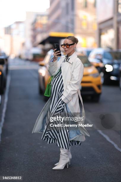 Guest seen wearing black sunglasses with orange lenses, gold necklace, Chanel gold earrings, white and navy blue striped pattern long dress, white...