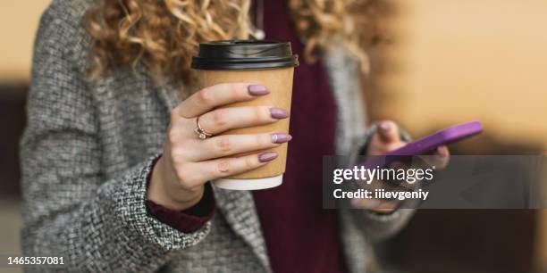 paper cup and mobile phone in hand - take away coffee cup stock pictures, royalty-free photos & images