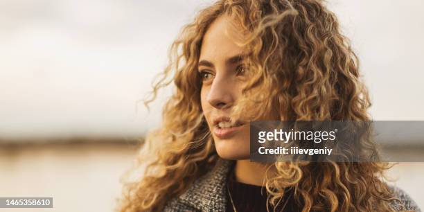 blonde curly girl in coat outdoors - beige jacka bildbanksfoton och bilder