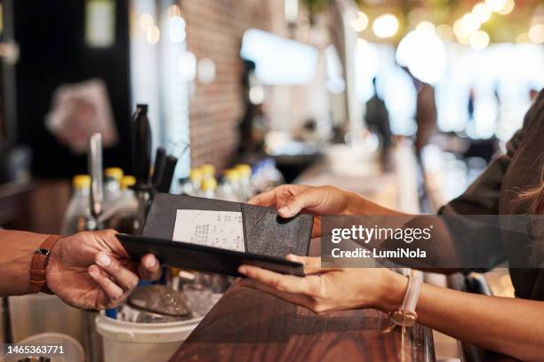 hands with bill, food service and people in restaurant, customer with receipt and payment with cashier or waiter. fine dining, dinner and check at cafe, catering and hospitality with finance - sonic corp restaurant ahead of earnings figures stockfoto's en -beelden