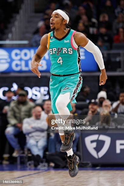 Devonte' Graham of the San Antonio Spurs skips after making a 3-pointer during overtime of a game against the Detroit Pistons at Little Caesars Arena...