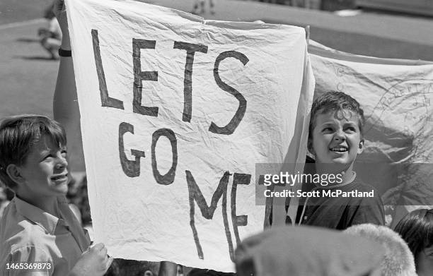 Two boys hold up a sign that reads 'Lets Go Mets' during a baseball game at Shea Stadium, in Queens' Corona neighborhood, New York, New York, June...