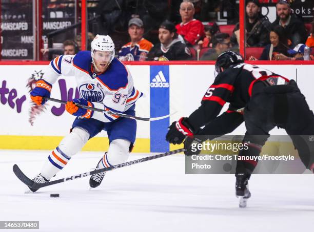Connor McDavid of the Edmonton Oilers skates with the puck against Jake Sanderson of the Ottawa Senators during the first period at Canadian Tire...