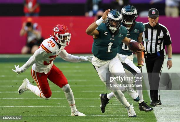 Jalen Hurts of the Philadelphia Eagles runs the ball against L'Jarius Sneed of the Kansas City Chiefs during the first quarter in Super Bowl LVII at...