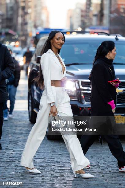 Jourdan Dunn wears white cropped blazer, pants, Audemars Piguet watch, silver bag outside Alice & Olivia during New York Fashion Week on February 11,...