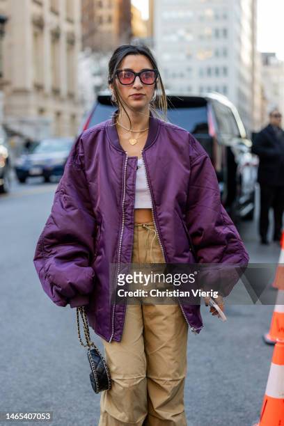 Natalie Parvizian wears purple bomber jacket, beige pants outside PatBo during New York Fashion Week on February 11, 2023 in New York City.
