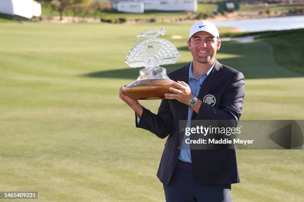 Scottie Scheffler of the United States celebrates with the trophy after winning during the final round of the WM Phoenix Open at TPC Scottsdale on...