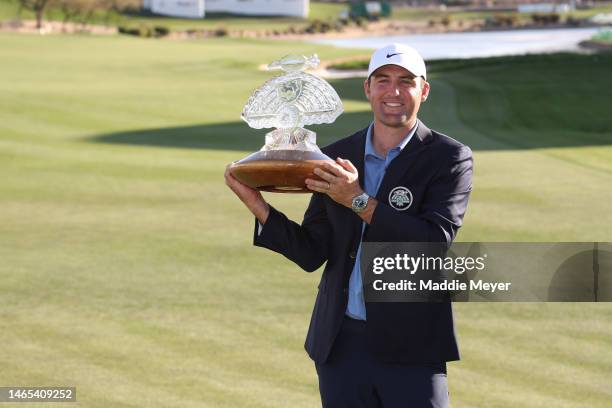 Scottie Scheffler of the United States celebrates with the trophy after winning during the final round of the WM Phoenix Open at TPC Scottsdale on...