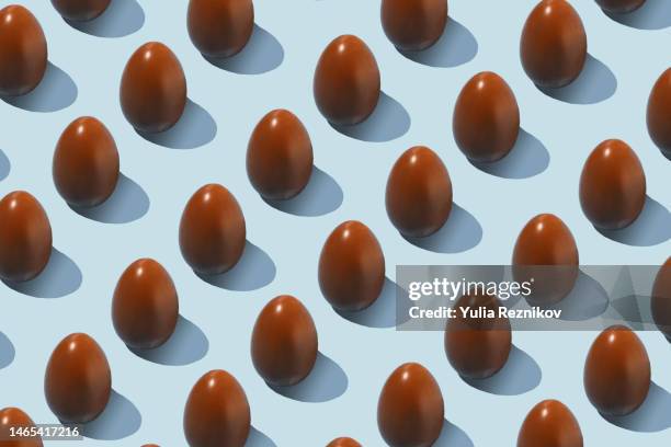 repeated easter chocolate eggs on the blue background - chocolate egg stock pictures, royalty-free photos & images