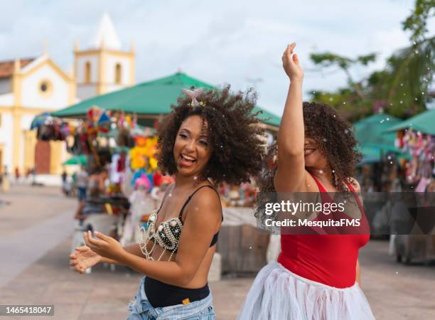 women throwing confetti at caranval do brasil - street party stock pictures, royalty-free photos & images