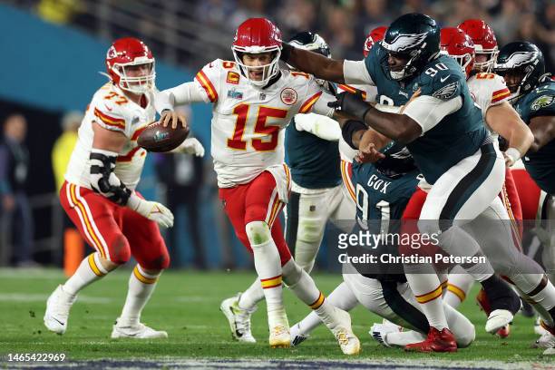 Patrick Mahomes of the Kansas City Chiefs scrambles away from Jordan Davis of the Philadelphia Eagles during the third quarter in Super Bowl LVII at...