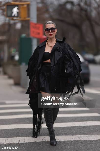Olga Ferrara is seen wearing Quay squared shades, a gold chain, black bra, Videmus Omnia black leather fringe jacket, heart black bag and black...