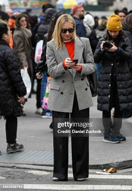 Lisa Aiken is seen wearing a gray jacket, red sweater, black pants and Ray Ban sunglasses outside the Jason Wu show during New York Fashion Week F/W...