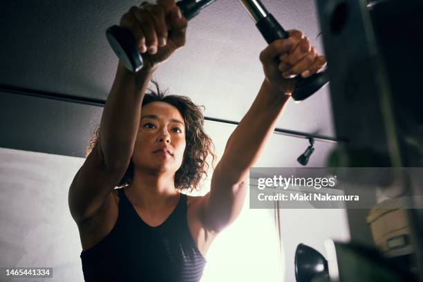 a woman in her 40s working out at a training gym. - strength training stock pictures, royalty-free photos & images