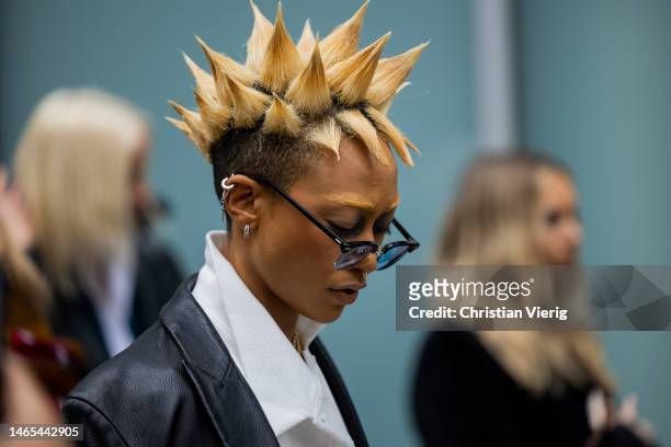 Actress Tati Gabrielle with blonde gelled hair style wears leather jacket, beige pants, white shirt outside Adeam during New York Fashion Week on...