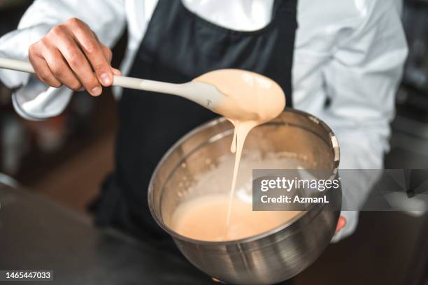 male hand and spoon checking consistency - grädde bildbanksfoton och bilder
