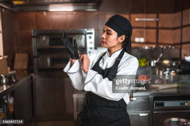food safety, female chef getting ready for cooking - zwarte handschoen stockfoto's en -beelden