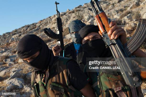 Fighters loyal to the Free Syrian Army pose with their weapons in a location on the outskirts of Idlib in northwestern Syria on June 18, 2012. Syrian...
