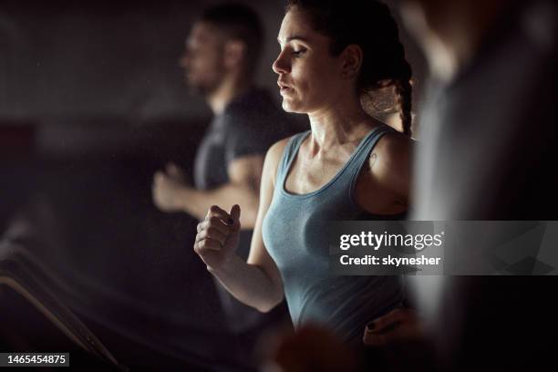 athletic woman warming up on treadmill in a gym. - runner warming up stock pictures, royalty-free photos & images