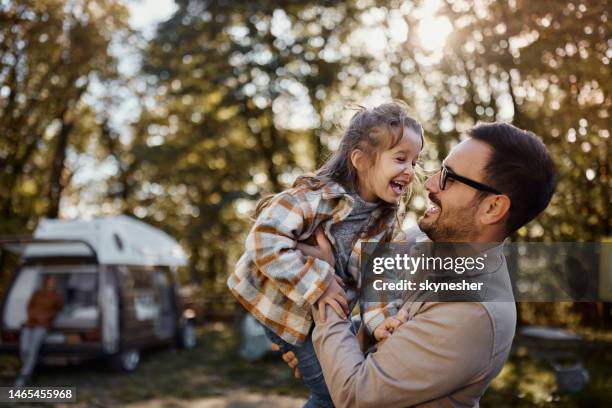 cheerful girl having fun with her father at trailer park. - father playing with daughter stockfoto's en -beelden