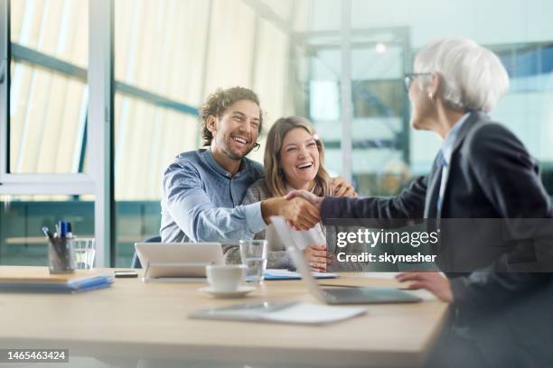 la pareja feliz llegó a un acuerdo con su agente en la oficina. - insurance fotografías e imágenes de stock