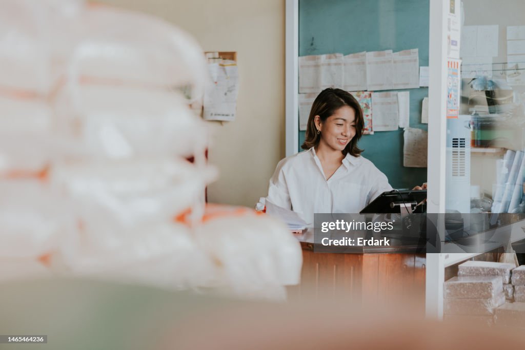 Dueña sonriente trabajando con su tienda mayorista de arroz