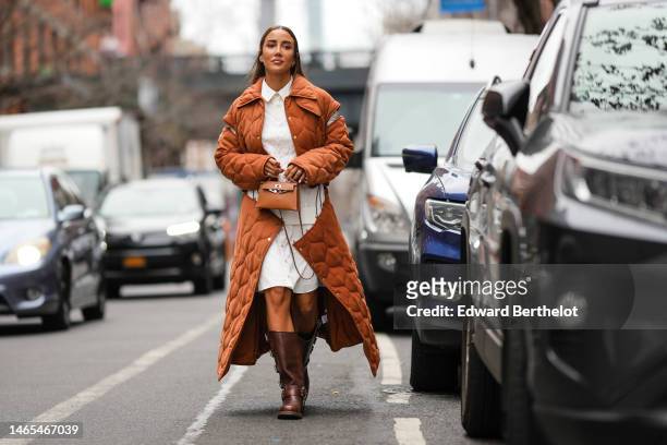 Tamara Kalinic wears rhinestones daisies pattern earrings, a white long shirt dress, a camel quilted embossed pattern / cut-out shoulder / zipper...