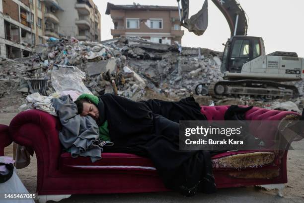 Man sleeps on a sofa near a collapsed building on February 13, 2023 in Hatay, Turkey. A 7.8-magnitude earthquake hit near Gaziantep, Turkey, in the...