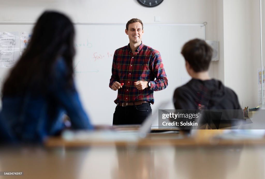 Teacher standing by white board in school class