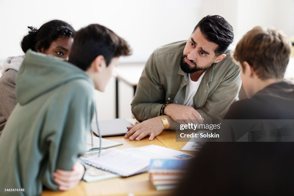 Teacher helping students in school classroom