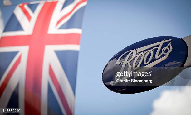 Union Jack flack flies in front of a sign outside a Boots store, operated by Alliance Boots, in London, U.K., on Tuesday, June 19, 2012. Walgreen...
