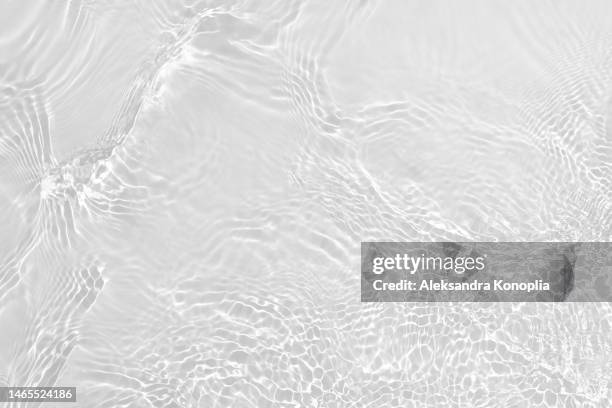desaturated transparent clear water surface texture with ripples, splashes and waves in sunlight - wateroppervlak stockfoto's en -beelden