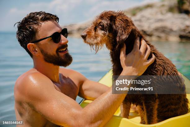 uomini belli che si divertono con il suo vecchio cane in kayak - kayaking foto e immagini stock