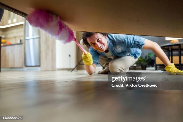 men cleaning under bed with pink duster - dusty cobwebs stock pictures, royalty-free photos & images