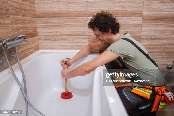 plumber unclogging a bathtube drain - drain stock pictures, royalty-free photos & images