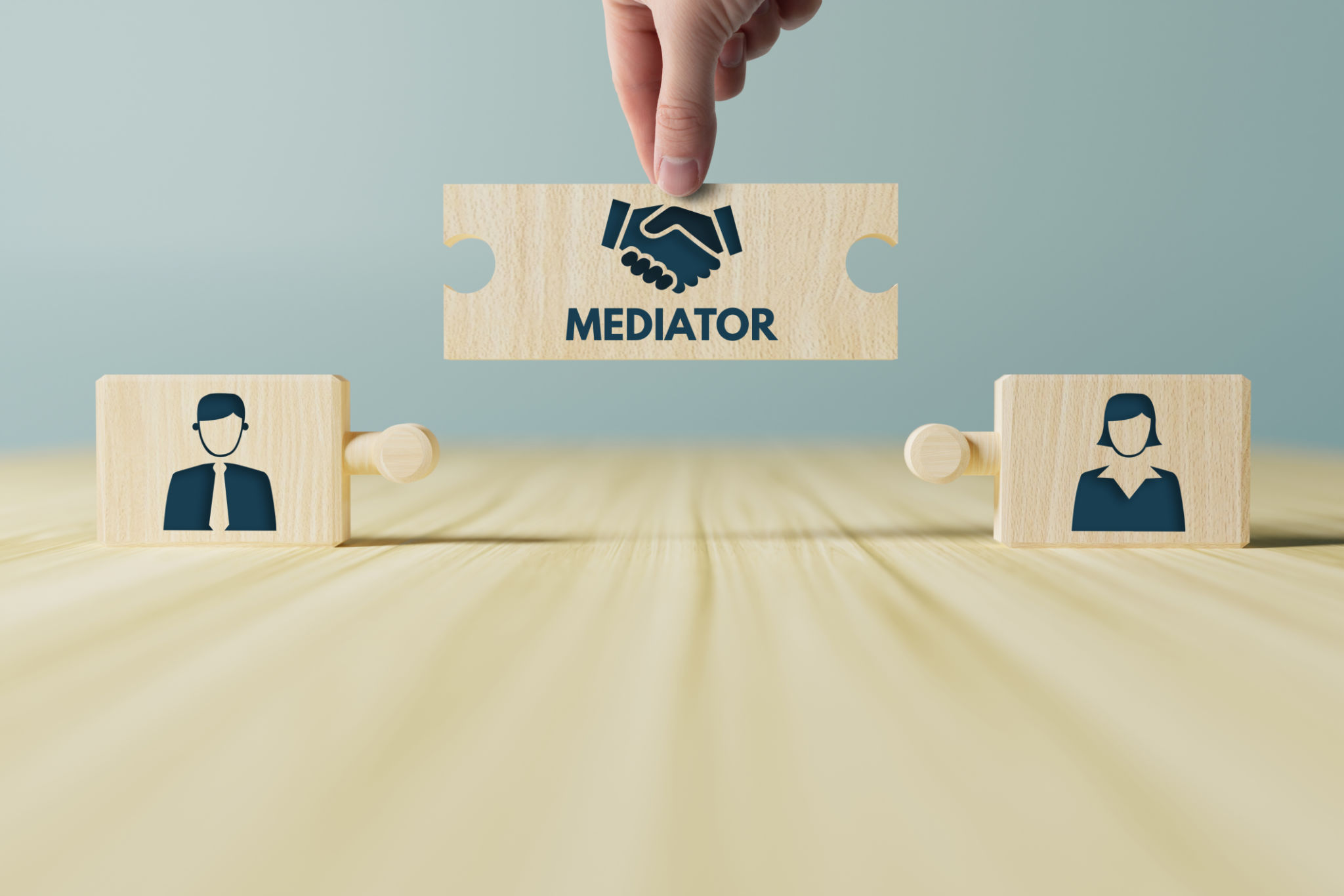 The hand holds wooden wooden blocks with icons of a woman and a man and shaking hands in the act of consent. The hand holds wooden wooden blocks with icons of a woman and a man and shaking hands in the act of consent.