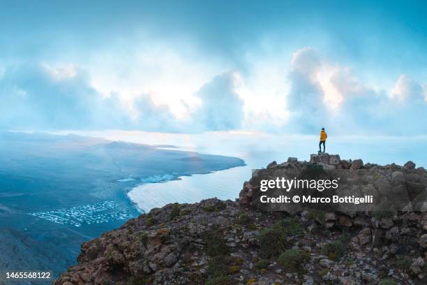 person admiring the view from top of a cliff. - sunset motivation stock pictures, royalty-free photos & images