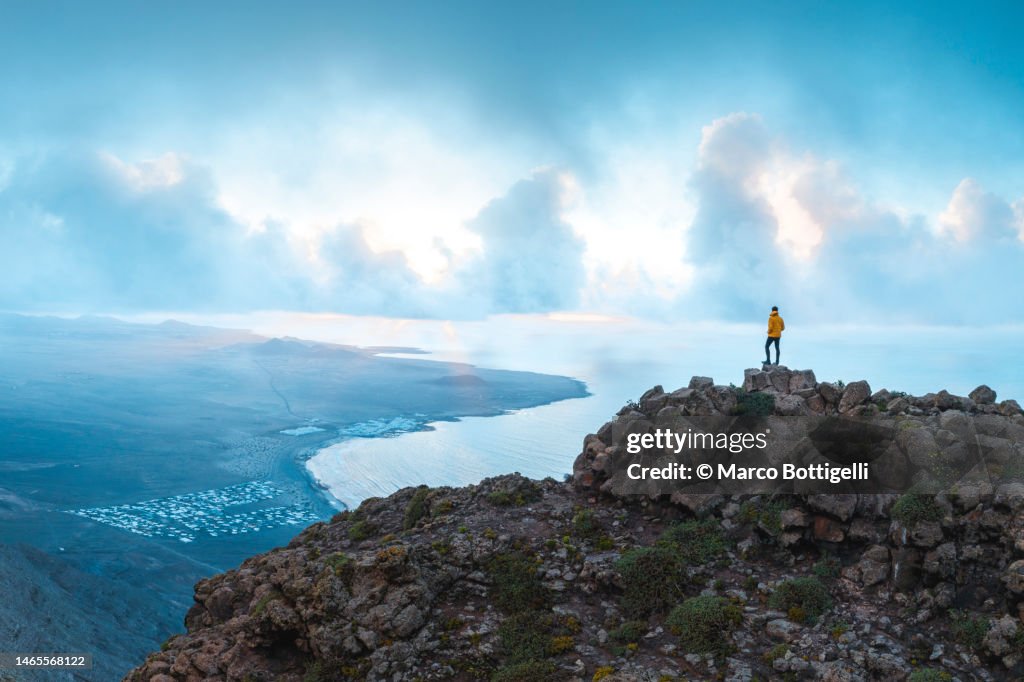 Person admiring the view from top of a cliff.