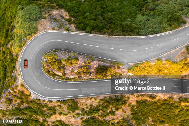 overhead view of hairpin curve on mountain road. - hairpin curve stock pictures, royalty-free photos & images