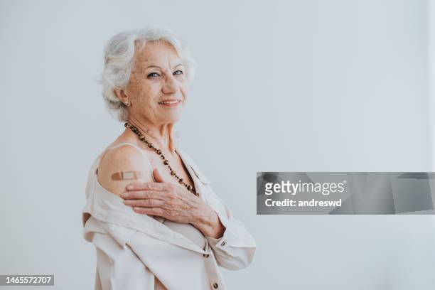 portrait of an elderly lady being immunized through the antiviral vaccine - corona virus white background stock pictures, royalty-free photos & images