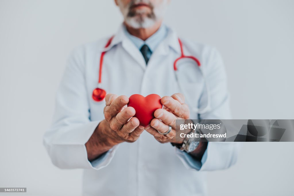 Retrato de un médico sosteniendo un corazón en sus manos