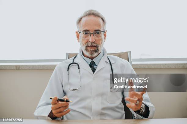 portrait of a doctor in a video conference call - doctors talking stock pictures, royalty-free photos & images