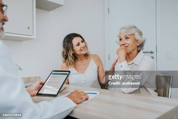 taking the elderly mother to a doctor's appointment - family with doctor stock pictures, royalty-free photos & images