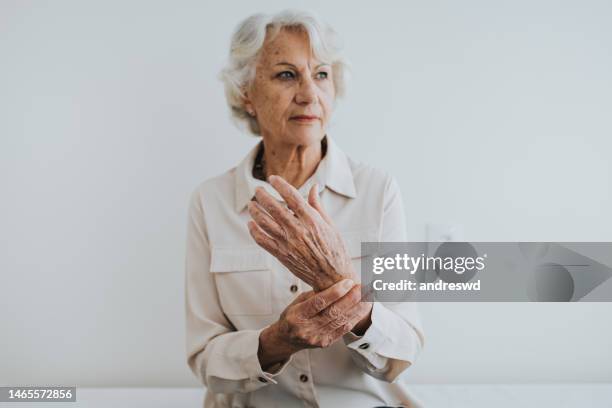 senior woman with hand wrist pain - osteoarthritis stock pictures, royalty-free photos & images