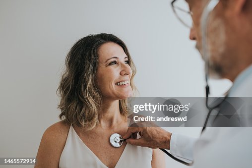 Arzt hört auf das Herz des Patienten mit Stethoskop Arzt hört auf das Herz des Patienten mit Stethoskop